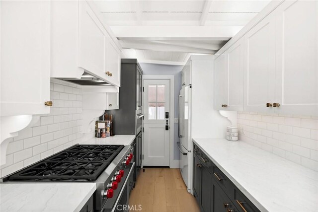 kitchen with backsplash, premium appliances, beamed ceiling, and white cabinetry