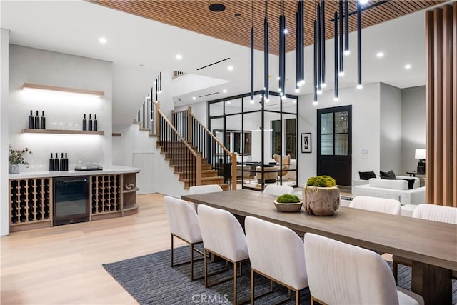 dining room featuring beverage cooler and light hardwood / wood-style flooring