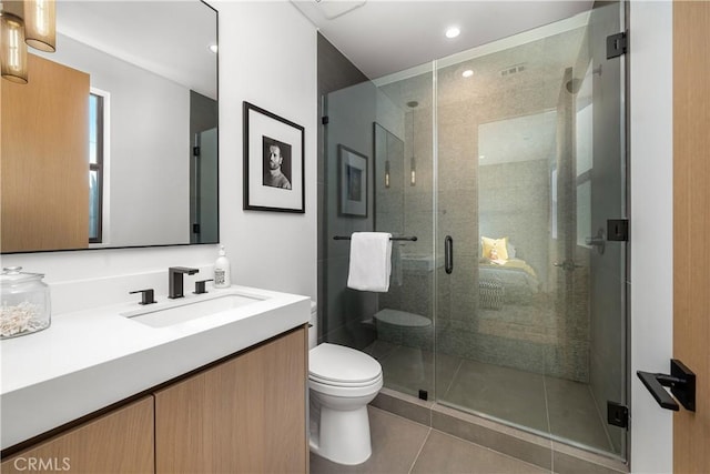 bathroom featuring tile patterned flooring, toilet, vanity, and walk in shower