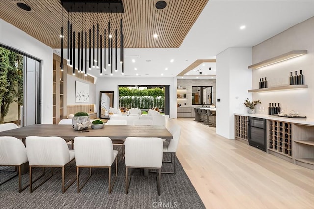 dining room with wooden ceiling, bar area, and light hardwood / wood-style floors