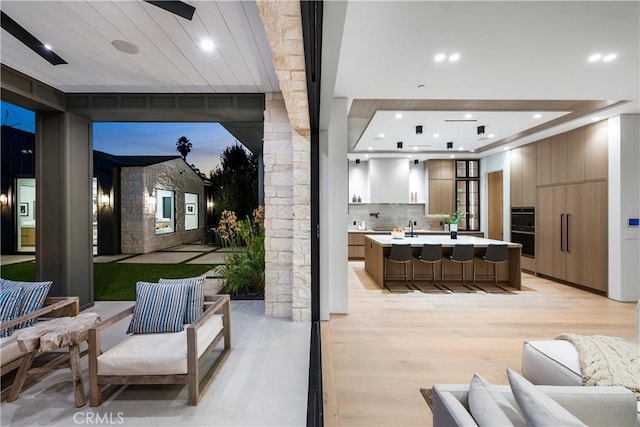 patio terrace at dusk with an outdoor hangout area and a wet bar