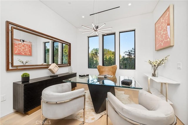 living area with light hardwood / wood-style floors and a notable chandelier