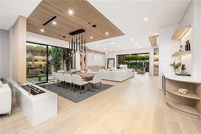 dining room featuring light wood-type flooring, plenty of natural light, and wooden ceiling