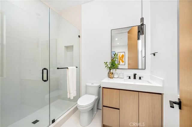 bathroom with toilet, vanity, and a shower with shower door