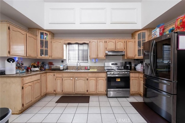 kitchen with light brown cabinetry, sink, stainless steel appliances, and light tile patterned flooring