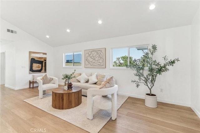 living room with light wood-type flooring and vaulted ceiling