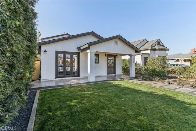 view of front facade featuring a front lawn and french doors