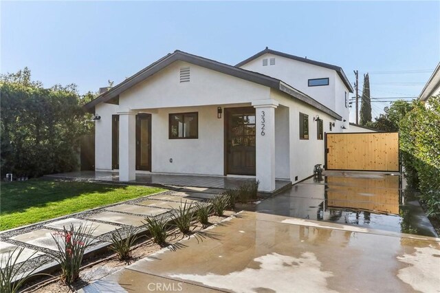 view of front of home with covered porch and a front lawn