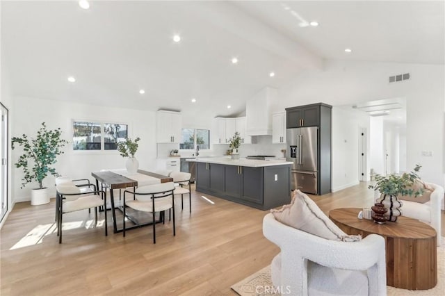 interior space featuring light wood-type flooring, beam ceiling, and high vaulted ceiling