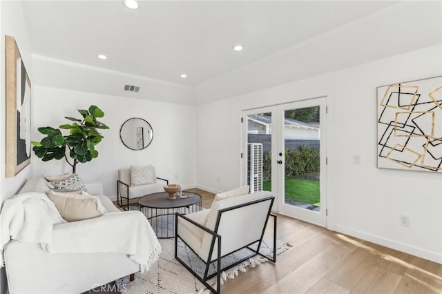 living room with french doors and light hardwood / wood-style flooring