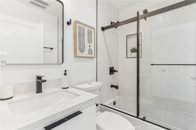 full bathroom featuring combined bath / shower with glass door, vanity, and toilet