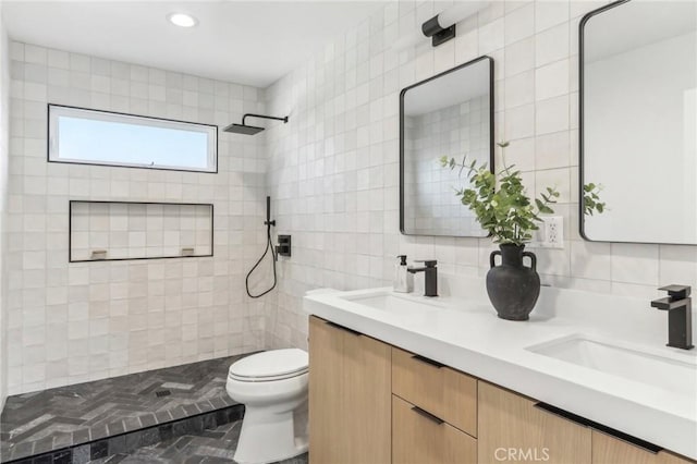 bathroom featuring vanity, backsplash, toilet, tile walls, and walk in shower