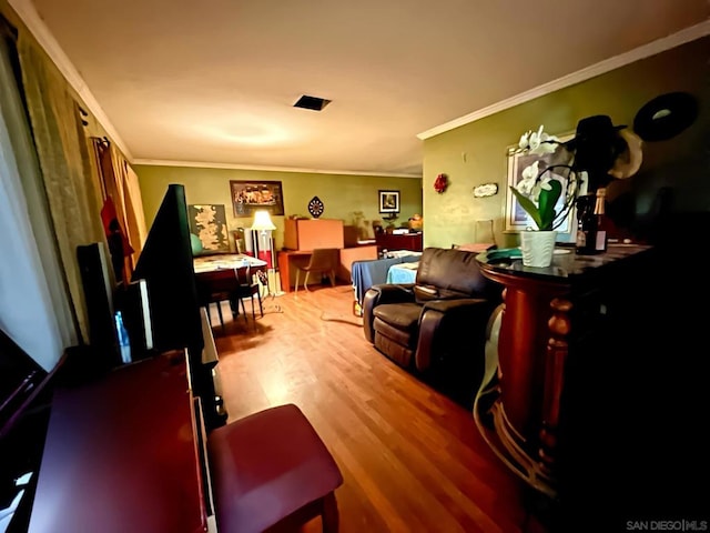 living room with crown molding and light hardwood / wood-style flooring