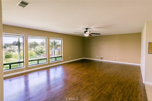 empty room with ceiling fan and dark hardwood / wood-style flooring