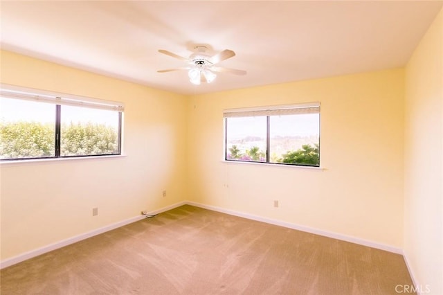 empty room with ceiling fan, plenty of natural light, and light carpet