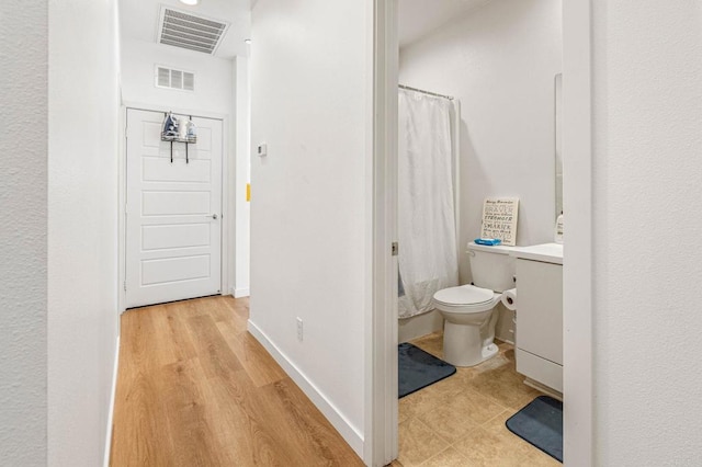 bathroom with walk in shower and toilet