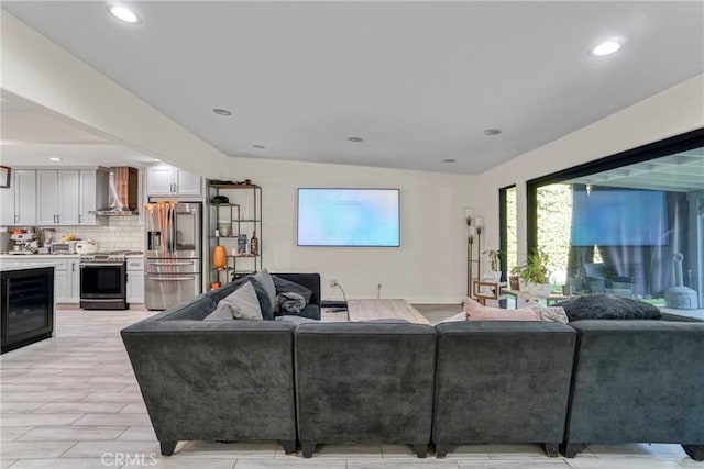 living room featuring lofted ceiling and beverage cooler