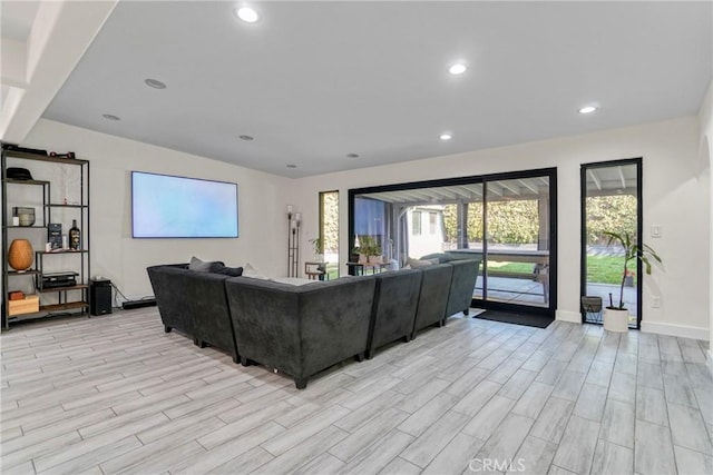 living room featuring recessed lighting, light wood-style floors, and baseboards