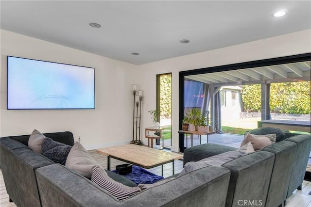 living area with recessed lighting, baseboards, and light wood-type flooring