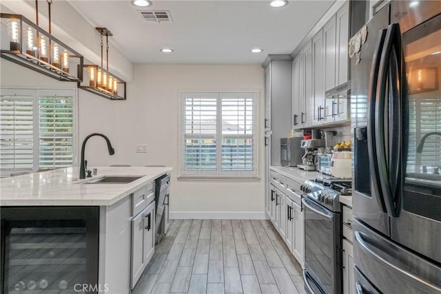 kitchen with visible vents, beverage cooler, recessed lighting, black appliances, and a sink