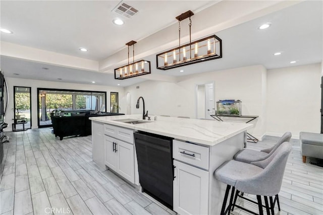 kitchen featuring white cabinetry, pendant lighting, dishwasher, and an island with sink