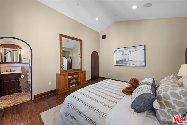 bedroom with sink, ensuite bathroom, dark hardwood / wood-style flooring, and lofted ceiling