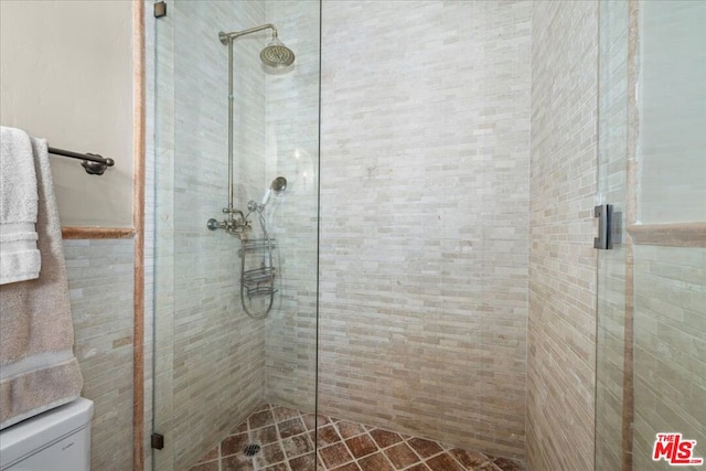 bathroom featuring toilet and a shower with door