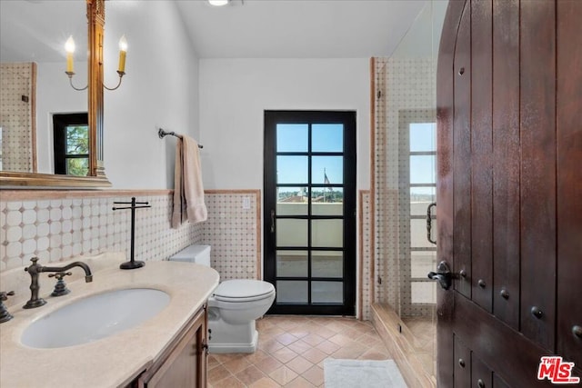 bathroom featuring vanity, toilet, tile walls, and an enclosed shower