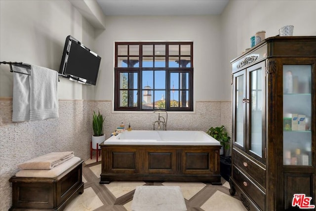 bathroom featuring a tub, tile walls, and tile patterned flooring