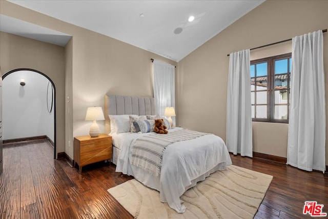 bedroom with dark wood-type flooring and lofted ceiling