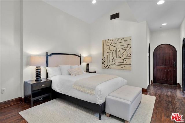 bedroom with lofted ceiling and dark hardwood / wood-style floors