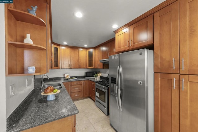 kitchen featuring sink, light tile patterned floors, stainless steel appliances, and dark stone countertops