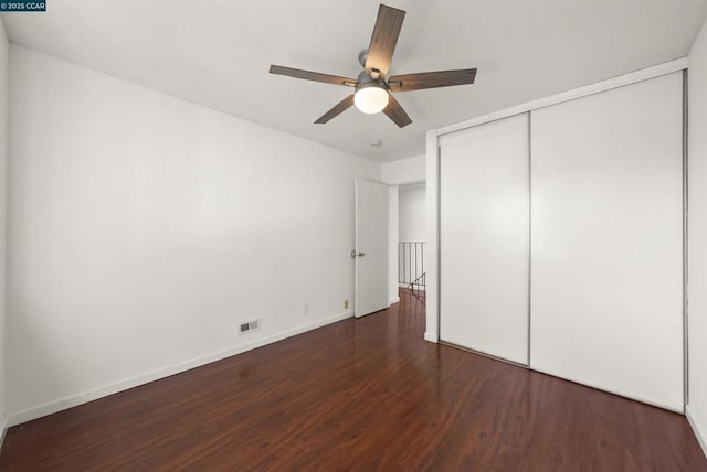 unfurnished bedroom with a closet, ceiling fan, and dark hardwood / wood-style floors