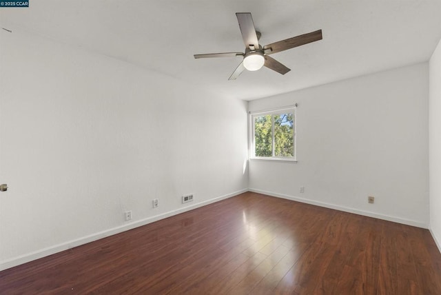 spare room featuring dark wood-type flooring and ceiling fan