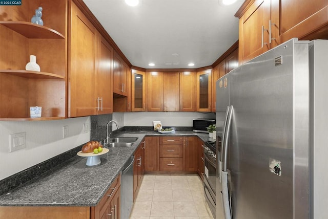 kitchen with light tile patterned floors, sink, appliances with stainless steel finishes, and dark stone counters