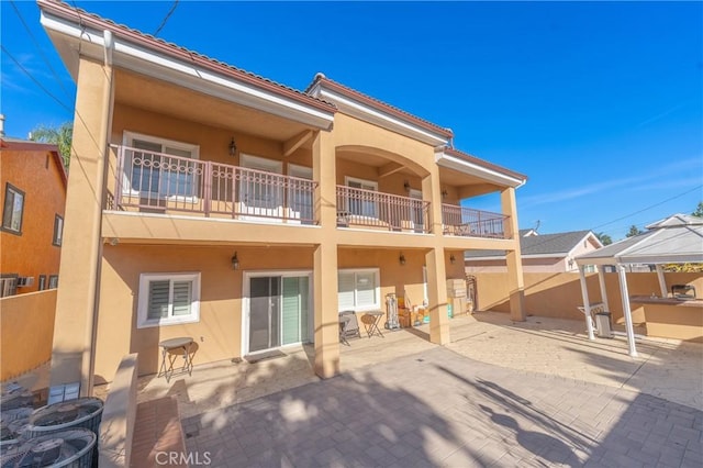 rear view of house with a gazebo, a balcony, and a patio area