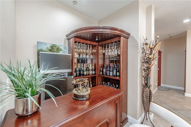 wine area featuring light tile patterned floors and bar area