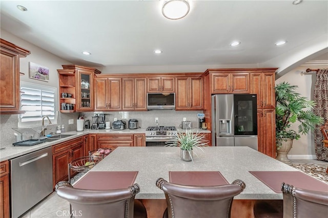 kitchen with sink, decorative backsplash, a kitchen breakfast bar, and appliances with stainless steel finishes