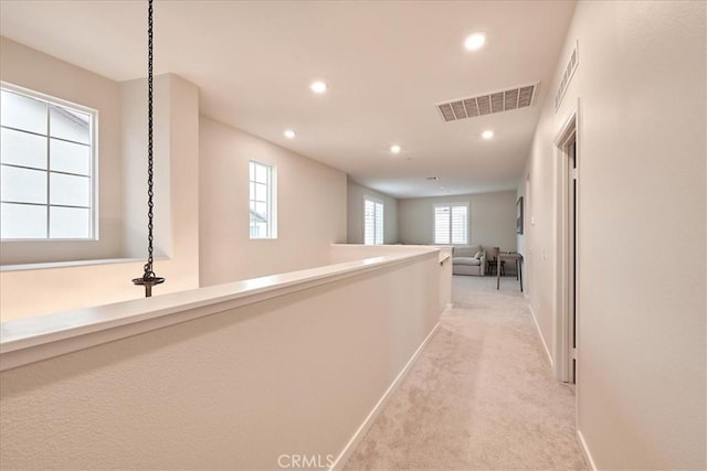 hallway featuring light colored carpet