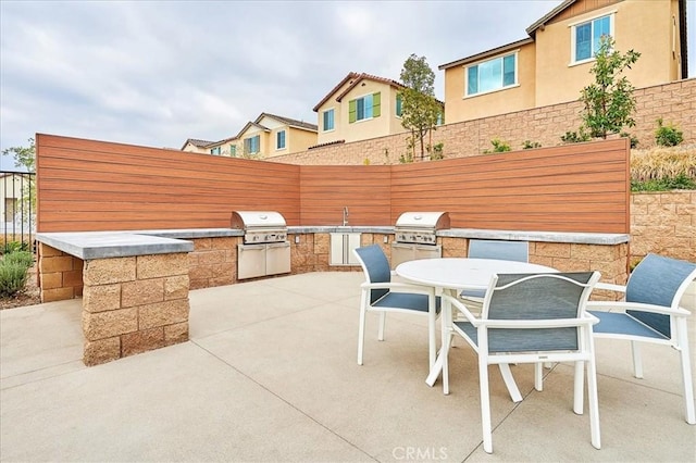 view of patio / terrace with an outdoor kitchen, area for grilling, and sink