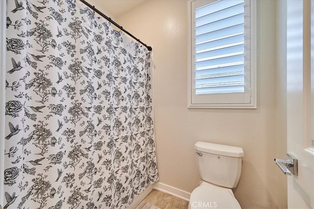 bathroom featuring curtained shower and toilet