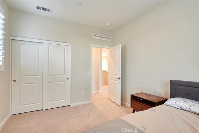 bedroom with light carpet and a closet