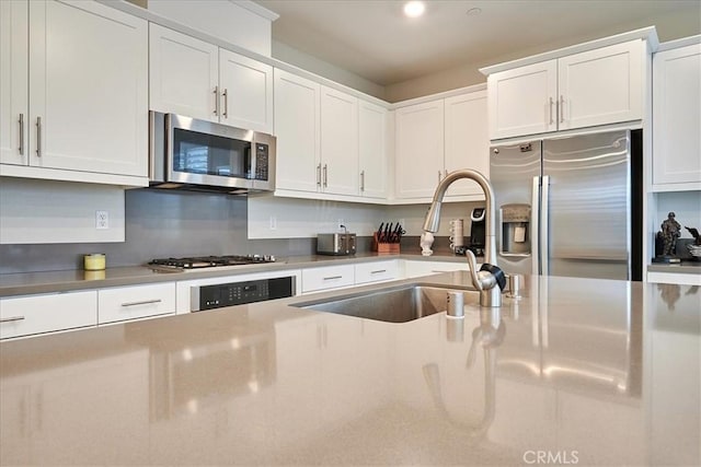 kitchen featuring stainless steel appliances, sink, and white cabinets