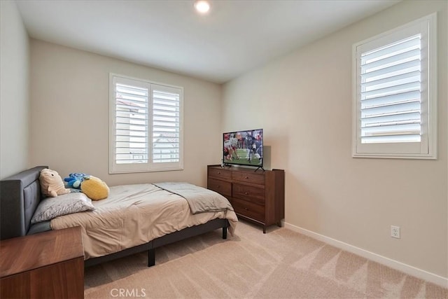 bedroom featuring multiple windows and light carpet