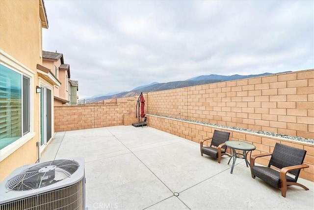 view of patio / terrace featuring a mountain view and central air condition unit