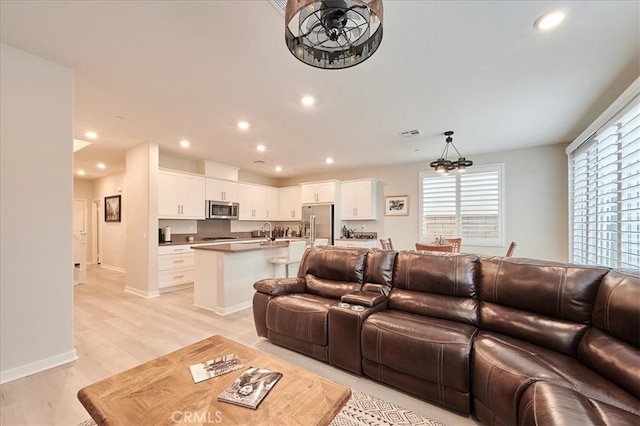 living room with sink and light wood-type flooring