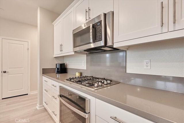 kitchen featuring stainless steel appliances, white cabinetry, and light wood-type flooring