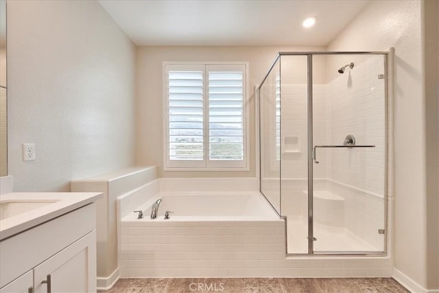 bathroom featuring vanity and shower with separate bathtub