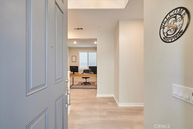 corridor with light hardwood / wood-style floors