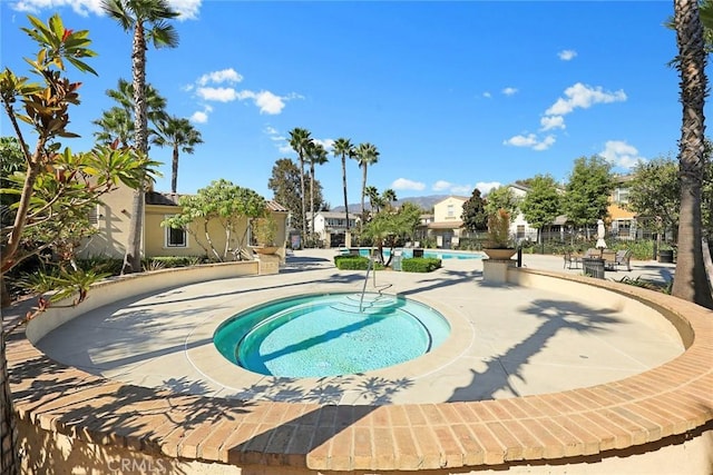 view of pool with a patio area and an in ground hot tub